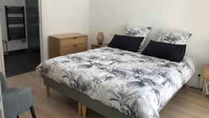 A bedroom with a bed, a nightstand, a dresser, and a chair. - Villa Agapanthes, perfect in any season, with heated swimming pool (Saint-Vincent-sur-Jard)