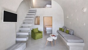 A modern interior with a staircase, a green sofa, a white table, and a grey bench. - Rhenia Suites-Prive Jacuzzi&Caldera View (Santorini)