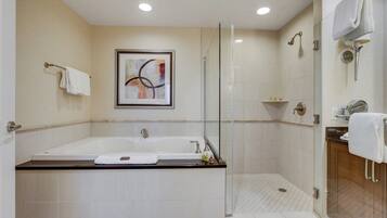 A modern bathroom with a bathtub, shower, and glass-enclosed shower area.