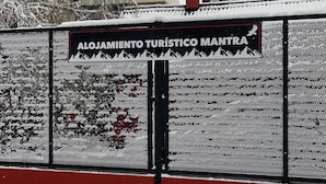 Uma cerca coberta de neve com uma placa que diz 'Alojamiento Turístico Mantra'.