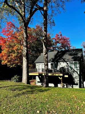 A two-story house with a deck and a covered patio. - Spacious 2 Bedroom Apartment on Rural, Wooded Property.  King Bed (Bow)