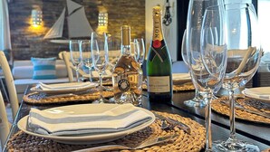 A dining table set with plates, cutlery, and wine glasses, with a bottle of Moët champagne and a bottle of Miraval on it.