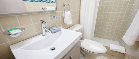 Une salle de bain avec un lavabo, un miroir et des toilettes.