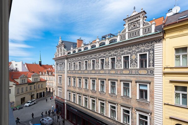 A multi-story building with ornate architectural details, a street view, and a clear sky.