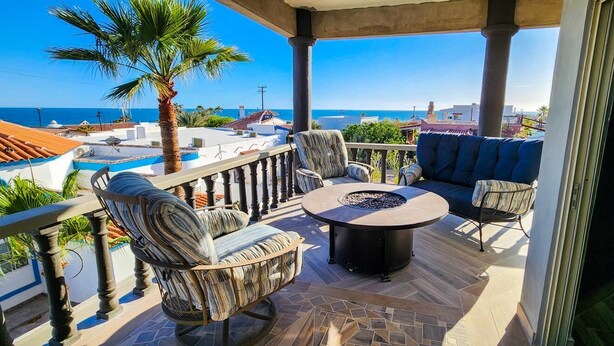 A balcony with a fire pit, seating, and a view of the sea. - Beautiful House (Las Conchas)
