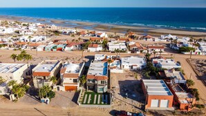 A coastal residential area with houses and a beach in the background. - Beautiful House (Las Conchas)