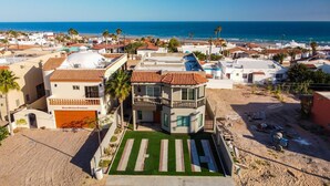 A coastal residential area with a two-story house featuring a balcony, a garage, and a well-maintained lawn. - Beautiful House (Las Conchas)