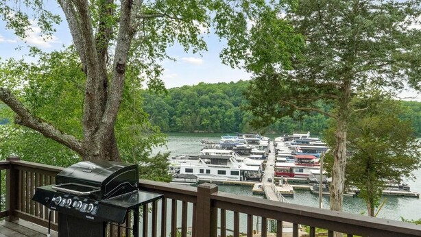 A deck with a grill overlooking a marina with boats. - 2 Bedroom Beacon Cottage 3 - Two bedrooms, one sleeper sofa and a kitchenette (Allons)