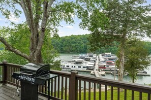 A deck with a grill overlooking a marina with boats. - 2 Bedroom Beacon Cottage 3 - Two bedrooms, one sleeper sofa and a kitchenette (Allons)