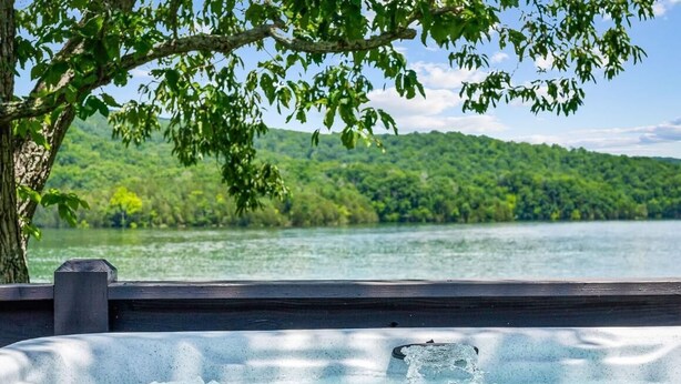 A hot tub with a view of a lake and forest. - Eagle's Perch Cabin 13 with Loft - One bed in loft, sleeper sofa and full kitchen (Allons)