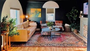 A living room with a sofa, coffee table, and potted plants. - The 'Posh Pickle'- Chic & Unique

 (louisville)
