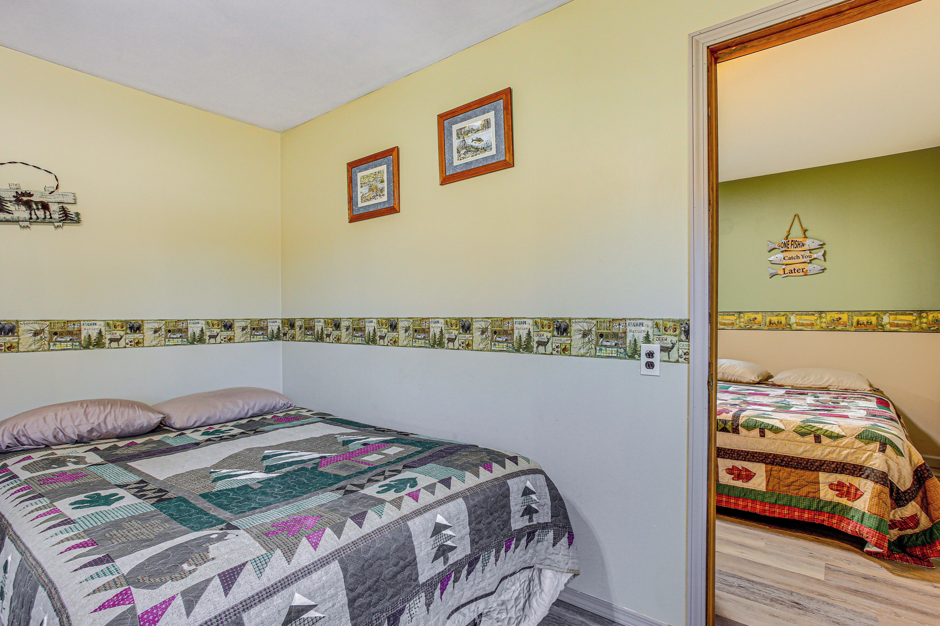 Une chambre à coucher avec un lit, une courtepointe et un mur orné de tableaux.