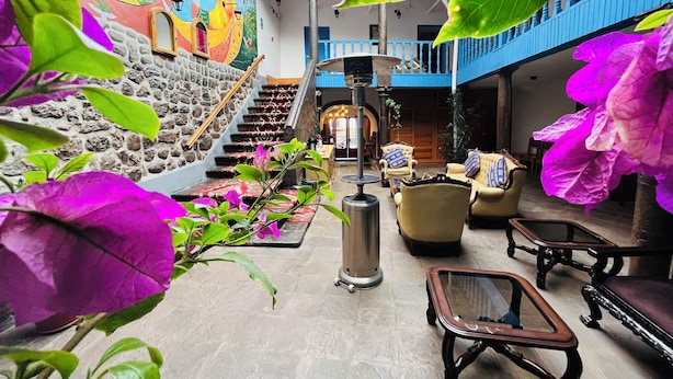Un hall d’entrée spacieux avec un escalier, des sièges confortables et une fresque murale.