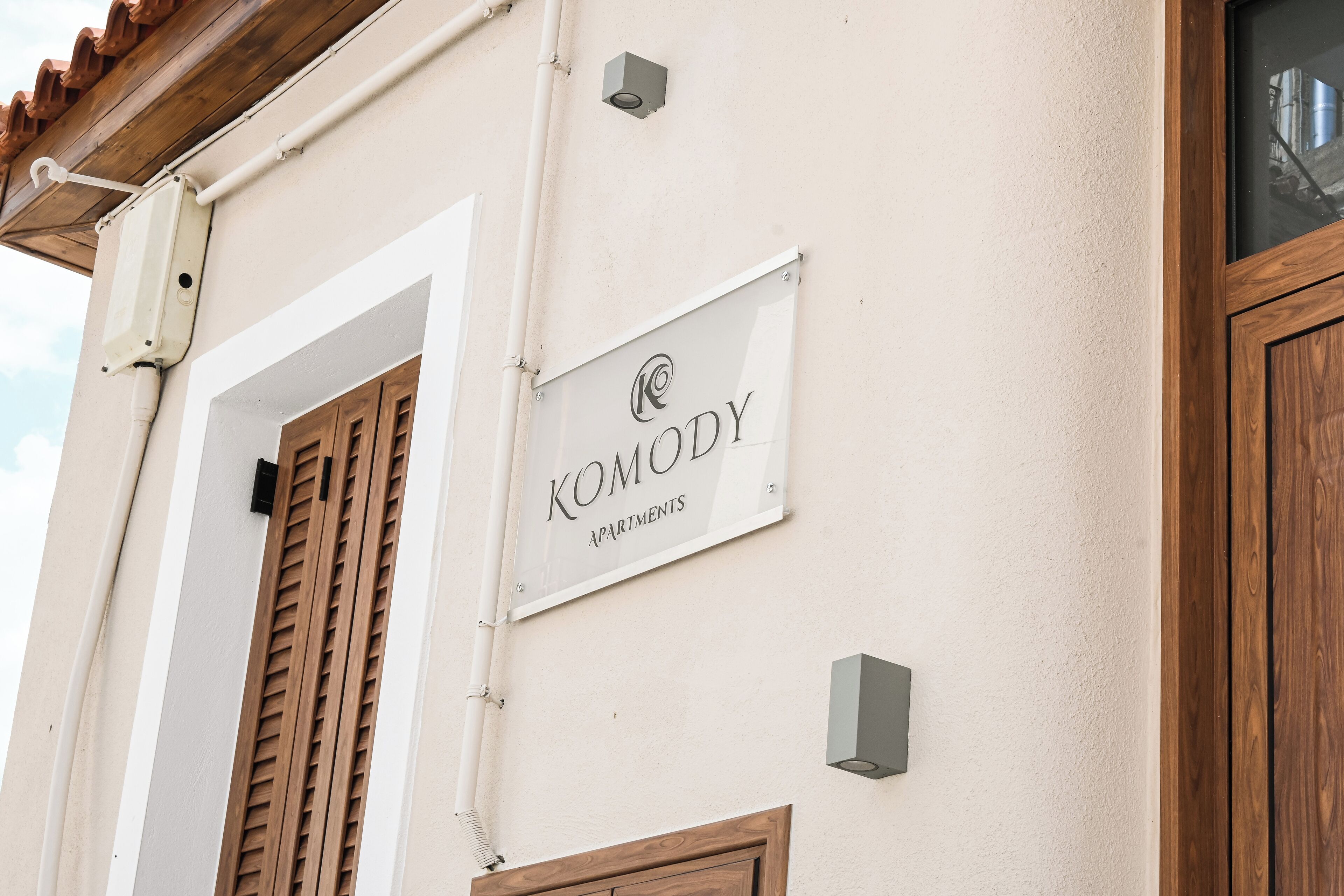 A building with a sign reading "Komody Apartments".