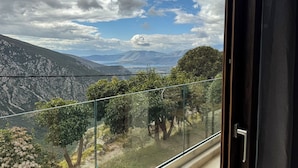 A balcony with a view of a mountainous landscape and a lake. - KOMODY (Delphi)