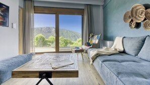 A modern living room with a large window, a sofa, a coffee table, and a chair. - KOMODY (Delphi)