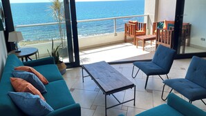 Ein Balkon mit Meerblick, ausgestattet mit einer Couch, Stühlen und einem Tisch.