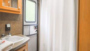 Ein Badezimmer mit Waschbecken, Spiegel und Fenster.