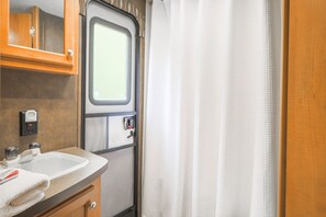 Un bagno con lavandino, specchio e finestra.