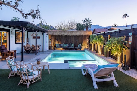 Una piscina al aire libre, sillones reclinables de piscina