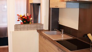 A modern kitchen with wooden cabinets, a stainless steel sink, and a built-in oven.