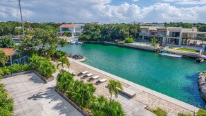A resort with a swimming pool, lounge chairs, and modern buildings. - Relaxing Waterfront Getaway in Puerto Aventuras (Puerto Aventuras)