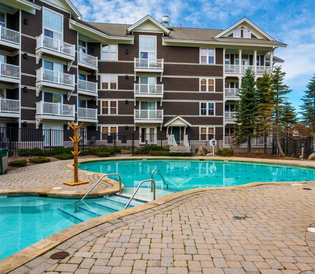 A multi-story residential building with balconies and a swimming pool.