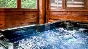A hot tub with a wooden exterior and a view of trees through the windows. - Mountain Retreat in the Smoky Mountain Near Dollywood (Pigeon Forge)