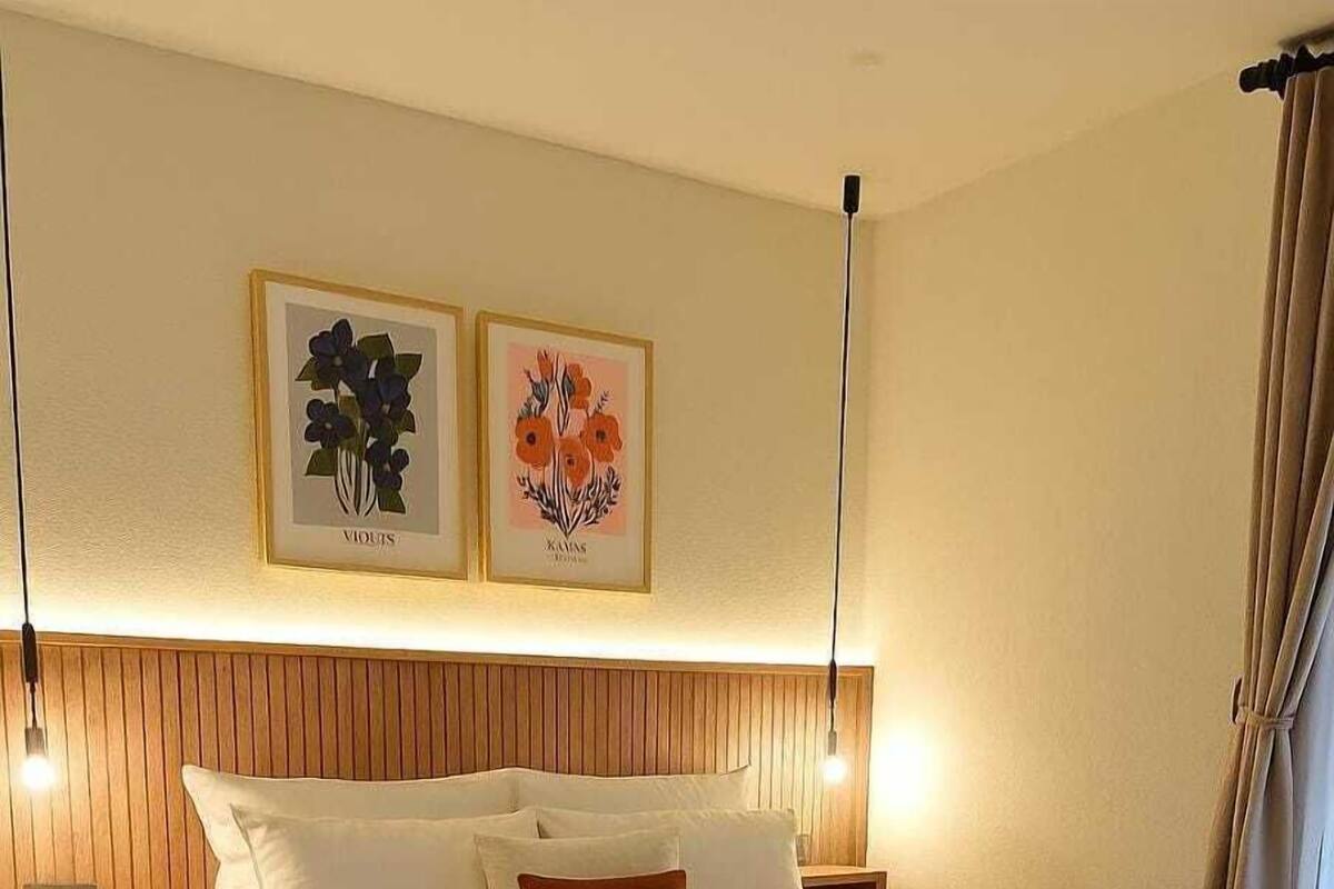 Ein großes Bett mit Holz-Kopfteil, zwei Nachttische und eine Wandleuchte.