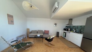 A modern apartment with a living area, kitchenette, and a dining space. - Cabanon Moderne, les Pieds Dans L'eau (Le Pradet)