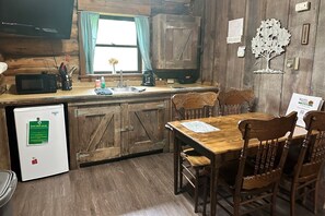 A rustic kitchen with wooden cabinets, a wooden dining table, and chairs.