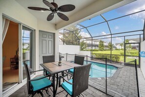 A covered patio with a pool, outdoor furniture, and a ceiling fan.