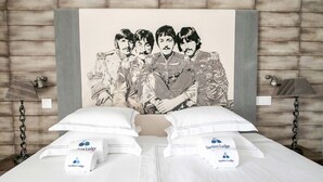 Una cama con ropa de cama blanca y dos almohadas, cada una con la etiqueta "Surfers Lodge".
