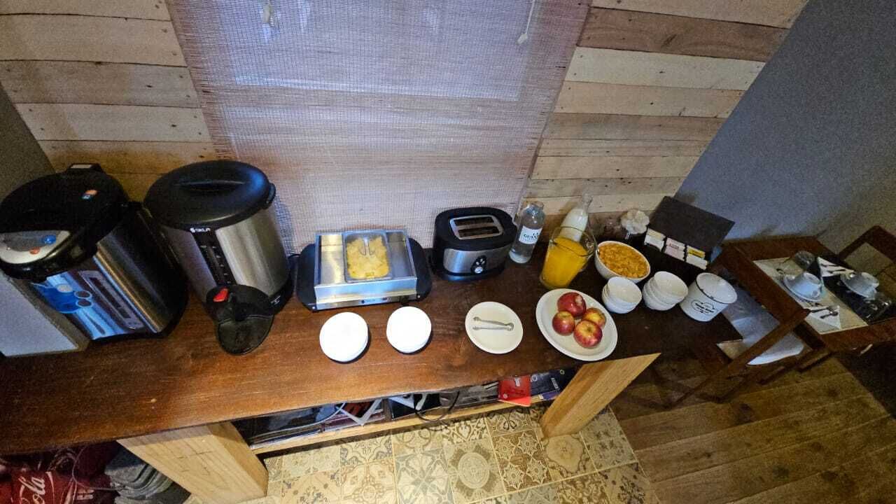Una encimera de cocina con varios electrodomésticos y alimentos, incluyendo una cafetera, un tostador y platos con comida.