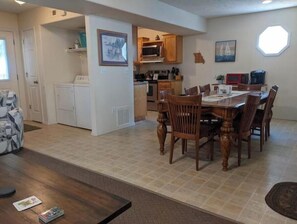 Cozy living space with a dining area, kitchen, and framed pictures on the walls.