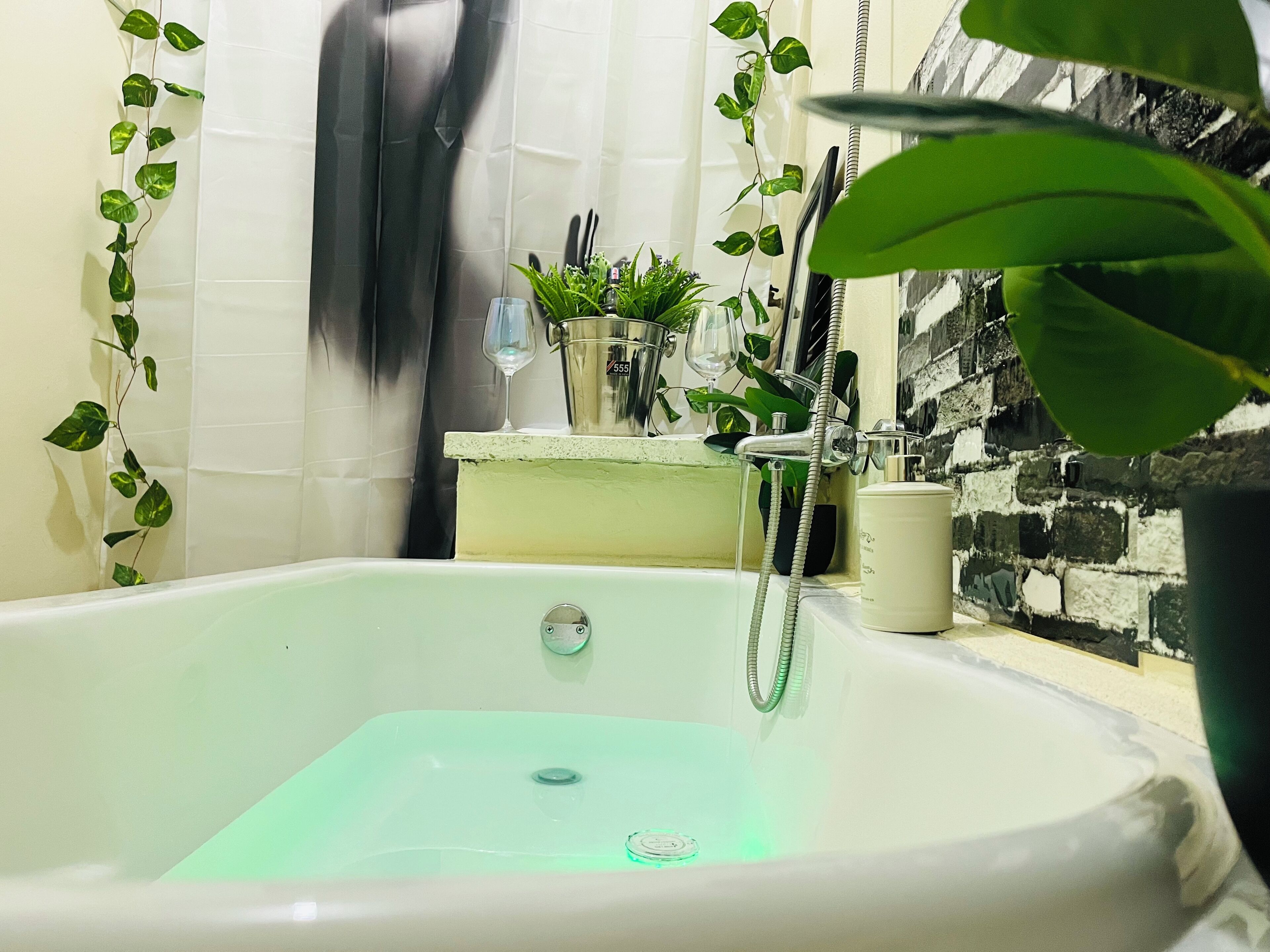 A bathroom with a white bathtub, a glass shower, and a sink.
