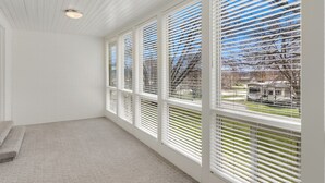 A room with large windows, a carpeted floor, and a staircase. - The Hideaway | 3 RV Hookups | Sleeps 17+ (Garden City)