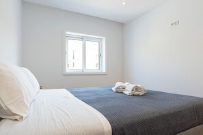 Ein Schlafzimmer mit einem Bett, einem Fenster und einer Steckdose.