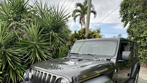 A black SUV parked on a gravel driveway with a license plate visible. - The best views on St. Thomas,  pool, Jeep rental (St. Thomas)