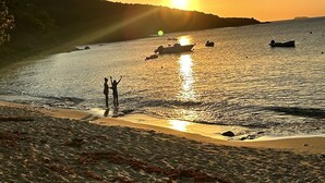 A beach scene with a sunset, boats on the water, and a person standing on the shore. - The best views on St. Thomas,  pool, Jeep rental (St. Thomas)