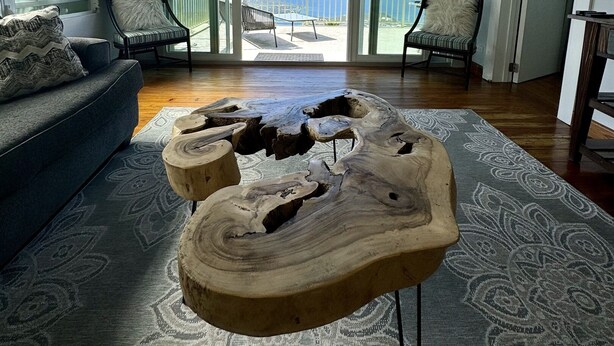 A spacious living room with a large wooden coffee table, a sofa, and two chairs. The room has a large sliding glass door leading to a balcony with a view of the ocean. - The best views on St. Thomas,  pool, Jeep rental (St. Thomas)