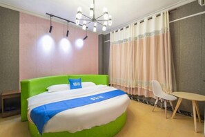 Una habitación de hotel con cama, una silla, una mesita y un candelabro.
