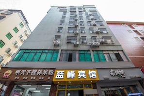 A multi-story building with a storefront at the ground level. - Lanfeng Hotel (Sanya)