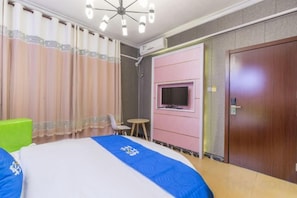 A hotel room with a bed, a television mounted on the wall, a small table, and a door. - Lanfeng Hotel (Sanya)