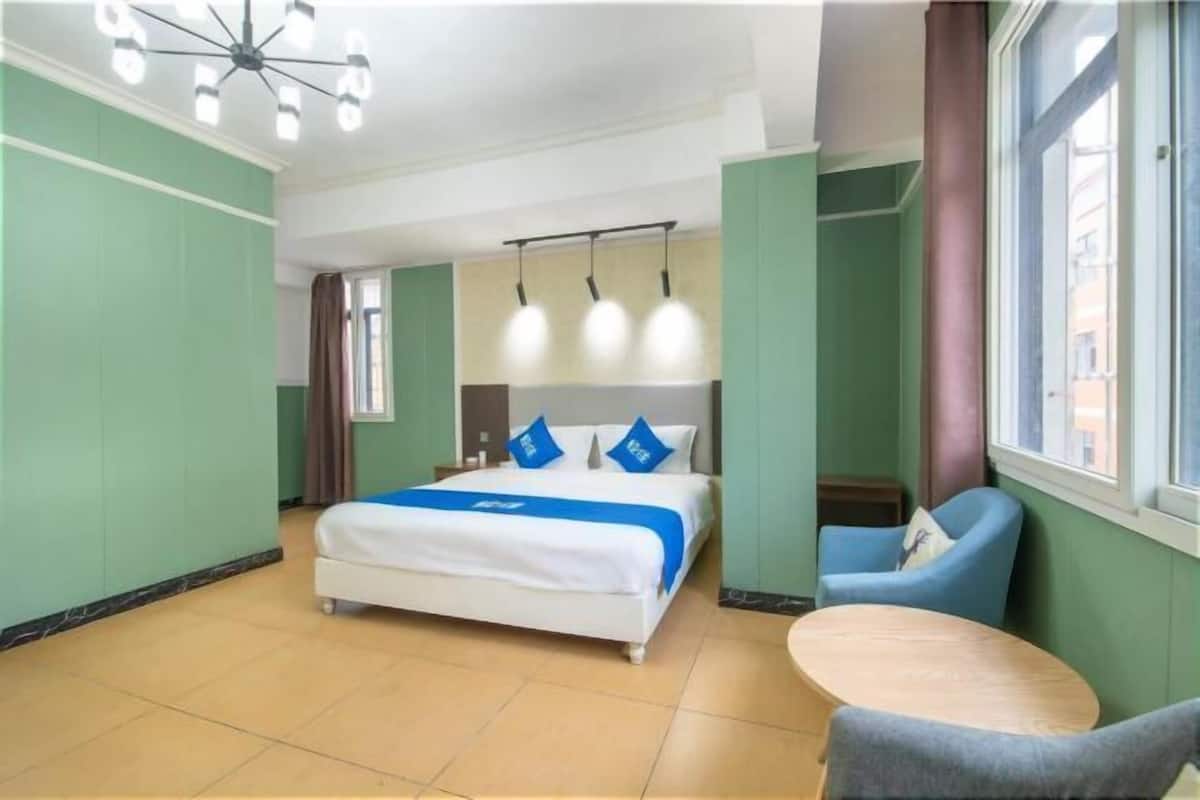 A hotel room with a bed, a round table, and a window.