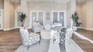 A spacious living area with a modern design, featuring two sofas, a coffee table, and decorative chairs.