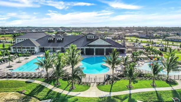 A large resort with multiple swimming pools, a central building, and surrounding greenery.