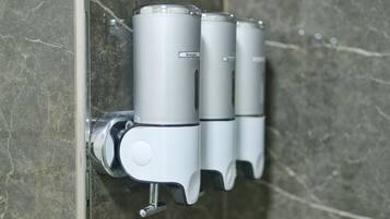 En väggmonterad dispenser med en etikett där det står ”Schampo”.
