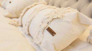 A plush, white, textured pillow with a tag labeled "BIZANO".