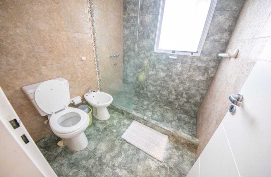 Une salle de bain équipée de toilettes, d’un bidet et d’un espace douche.